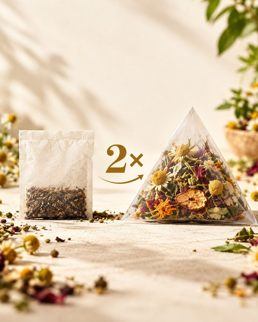 A flat paper tea bag of fine dust beside a full pyramid bag of whole botanicals