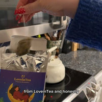 Lifting a pyramid sachet out of the carton