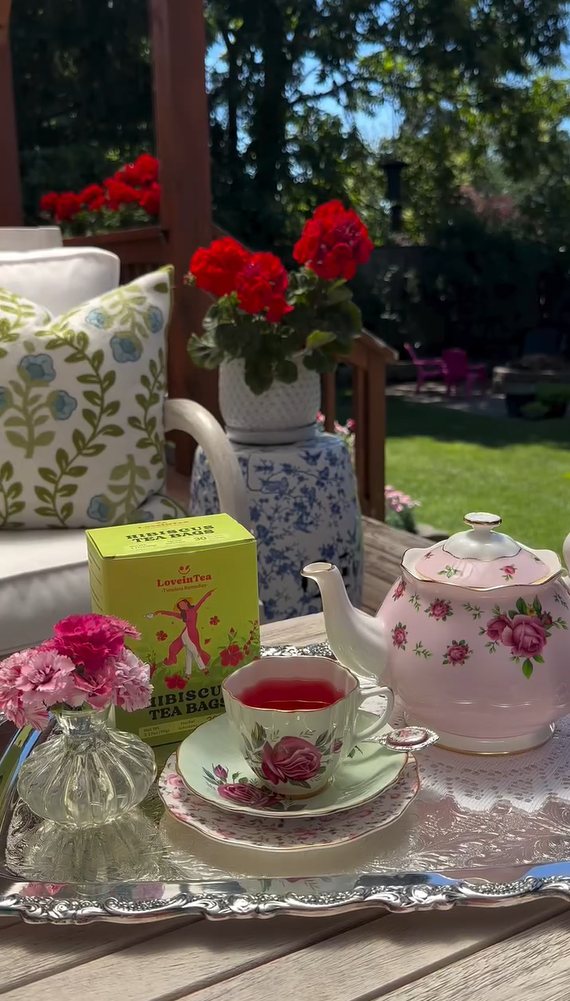 Rose teacup of hibiscus tea on a garden tray