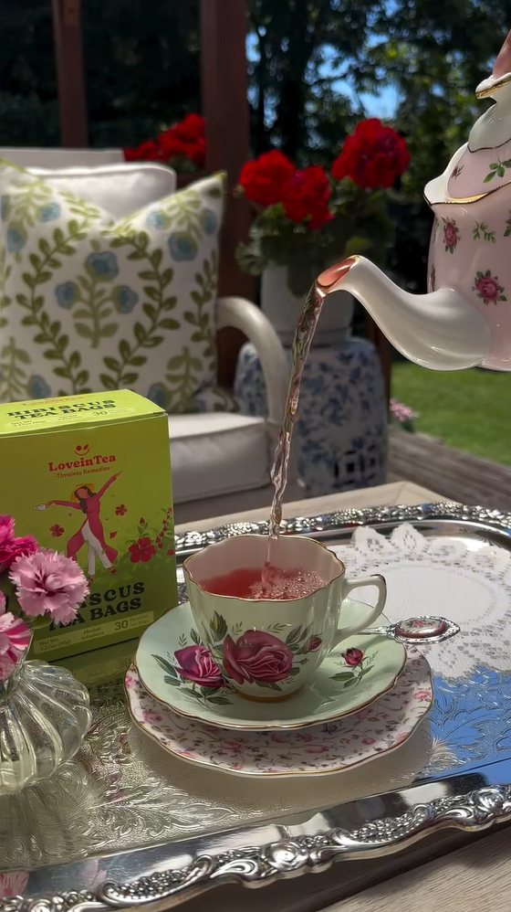 Hibiscus tea poured into a rose teacup in a garden