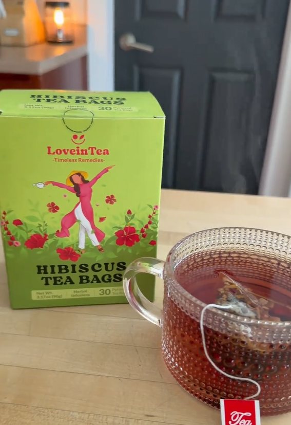 Hibiscus box beside a hobnail glass mug of red tea